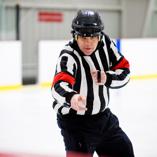 hockey referee calling a penalty